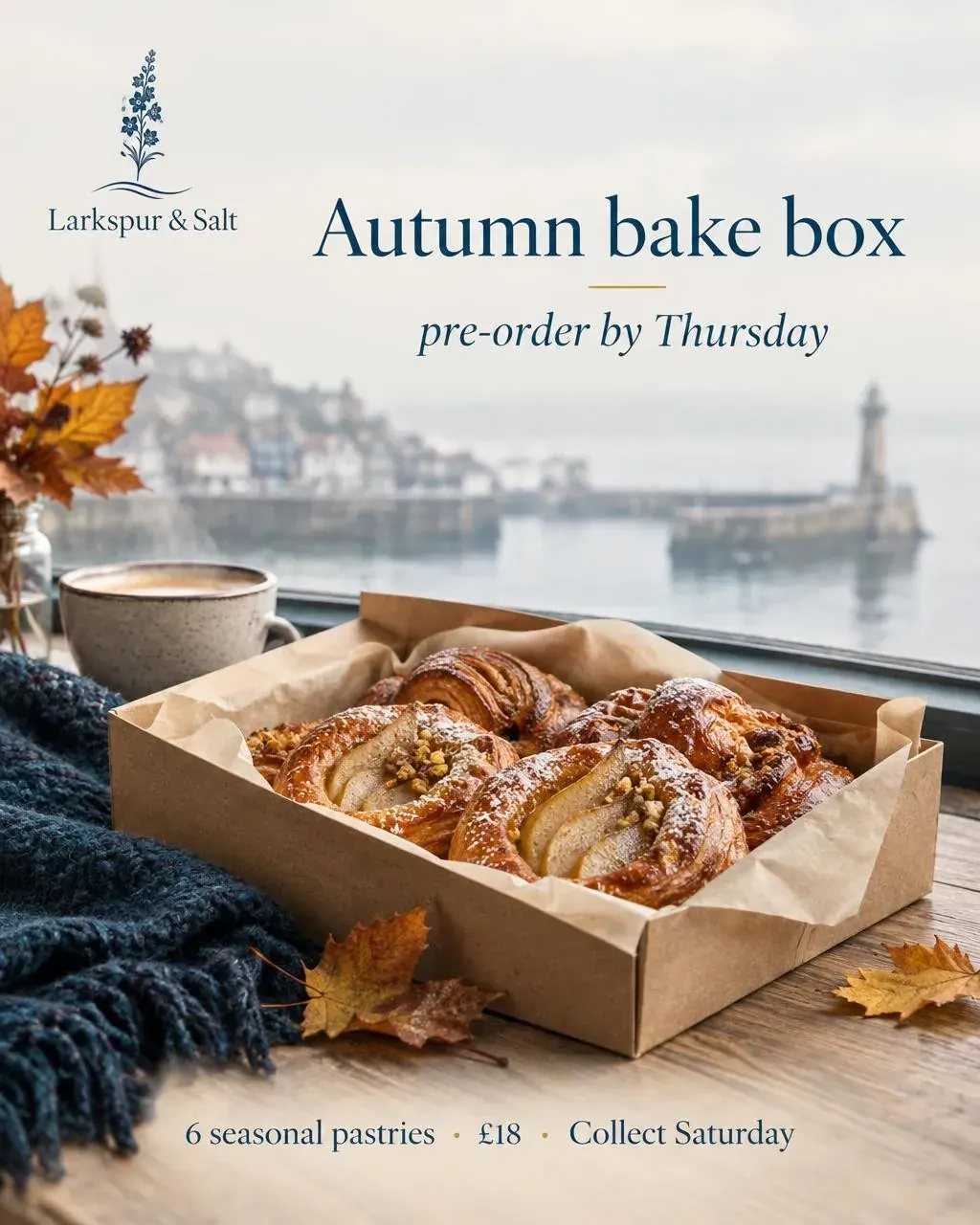 A box of pear pastries and a coffee by a window looking out over a misty harbour and lighthouse